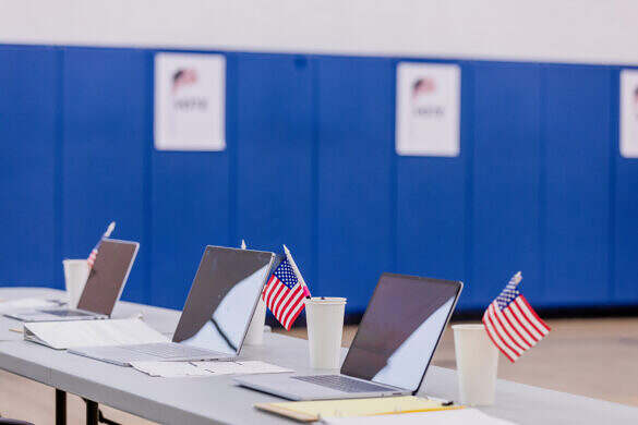 The laptops have been organized on the volunteer table so that the staff is able to sign in voters as they arrive to participate in the election.