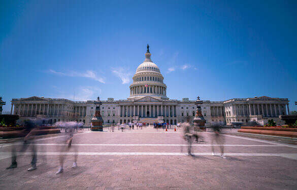 Wide Angle View of the US capitol during Day time with Blue Skies and tourists