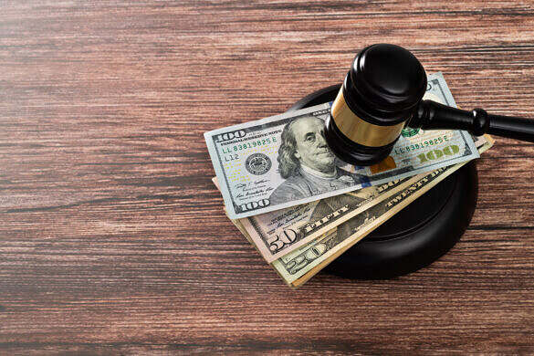Gavel and stack US paper currency on the table.